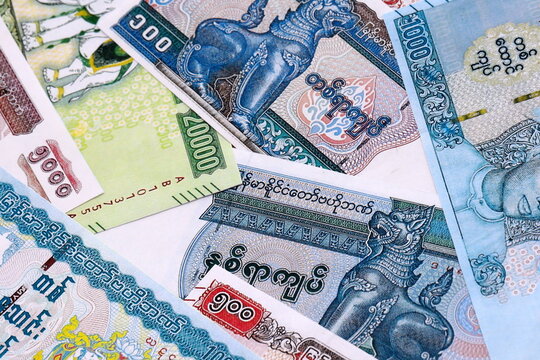 Myanmar kyat money bills pile on table. Myanmar banknotes of MMK currency close up.