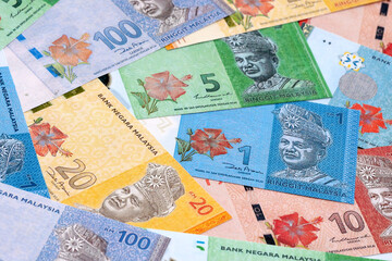 Malaysian ringgit money bills pile on table. Malaysia banknotes of MYR currency close up. © Larysa