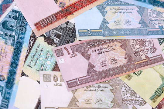 Afghan afghani money bills pile on table. Afghanistan banknotes of AFN currency close up.