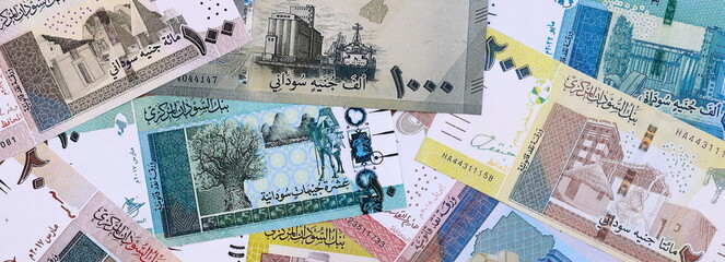 Sudanese pound money bills pile on table. Sudan banknotes of SDG currency close up.