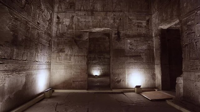 Dendera temple interior sanctuary with illuminated hieroglyphic walls and ritual reliefs in Egypt, ancient sacred chamber with dramatic lighting on carved sandstone surfaces.