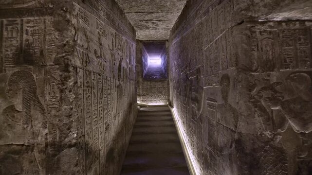 Dendera temple corridor with illuminated hieroglyphic walls and ritual reliefs in Egypt, ancient sacred chamber with dramatic lighting on carved sandstone surfaces.