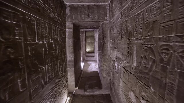 Dendera temple underground crypt corridors with hieroglyphic reliefs on walls in Egypt, narrow ancient passageways with carved inscriptions.