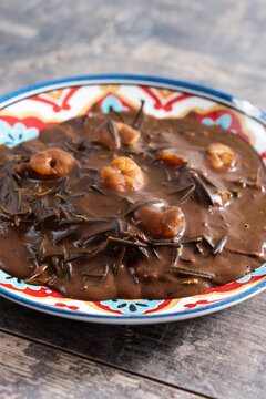 Mexican romeritos with mole sauce and shrimp on wooden table