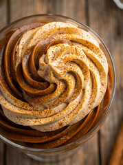 Fototapeta premium Macro of whipped Dalgona coffee foam with thick creamy texture over cold milk. Trendy Korean coffee drink concept for cafe advertisement and blog.