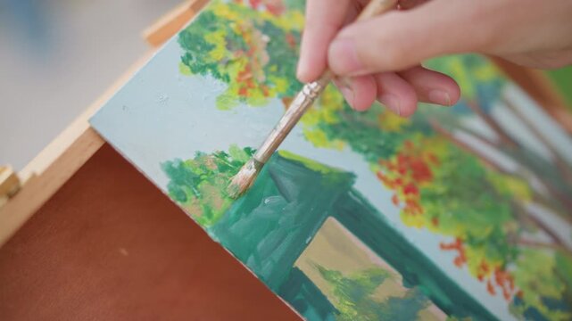 detail painter adding final strokes leaves closeup on brush refining foliage near green doorway structure, quick dabs of warm color, portable easel box in soft outdoor light, autumnal palette, careful