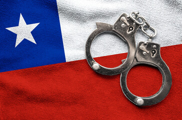 Flag of Chile and police handcuffs. Crime and offenses in country Concept
