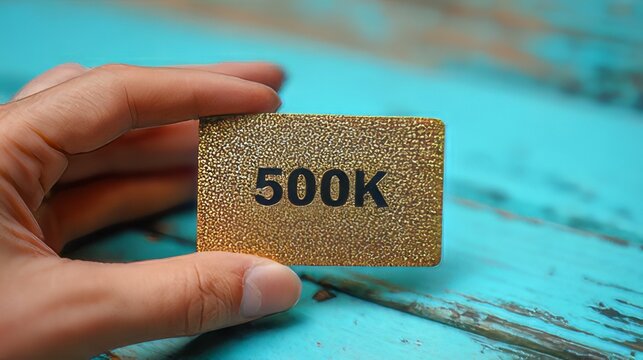 Celebration milestone card recognizing an achievement of 500,000 followers, subscribers, or views. Hand holding 500k shout out subscribers  golden card thank you. 