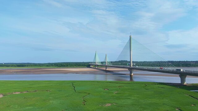 Liverpool, Merseyside, UK, June 19, 2025; Aerial 4K video footage of the Mersey Gateway toll bridge with stunning views over the River Mersey, Liverpool, UK.