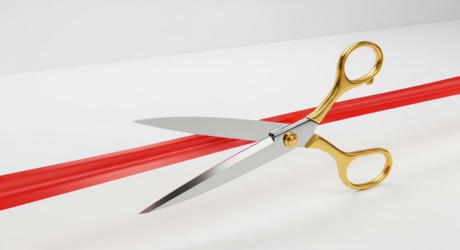 Gold scissors cutting a red ribbon on a white background