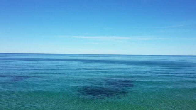 Tranquil blue Mediterranean sea with clear sky on a sunny day in Palinuro, Italy. Serene seascape with calm water and natural beauty.