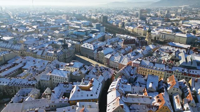 Aerial view of snow covered rooftops creating a striking contrast with the city's architecture, Graz, Styria, Austria.