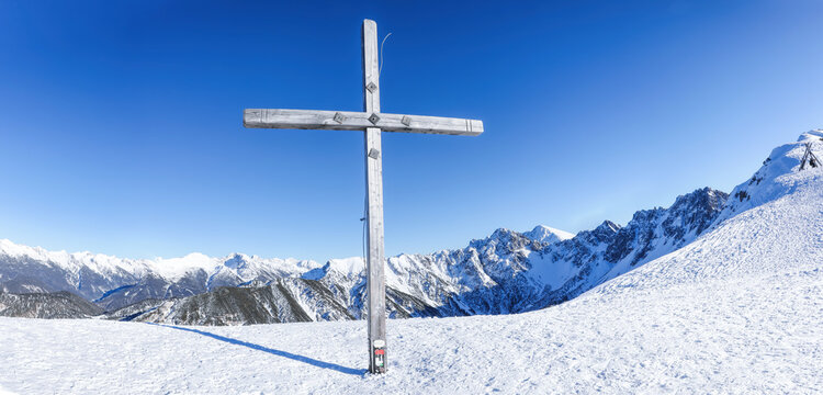Panorama of winter landscape with cross and snow covered Alps in Seefeld inTirol, Austria