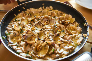 Clams and seafood cooking in a rich sauce