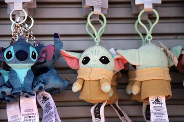 Fototapeta premium Grogu and Stitch plush keychains displayed for sale in retail store