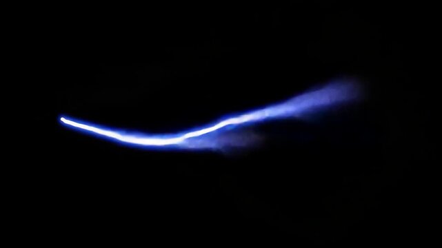 Powerful blue electric lightning bolt striking across a dark black background for visual effects