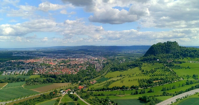 Sky view of city and landscape near mountain in Germany during daytime with clouds in the sky and fields below