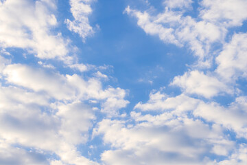 Obraz premium Soft white cumulus clouds on a clear blue sky background,A beautiful high-angle shot of fluffy white clouds scattered across a bright blue sky during a sunny day. This natural background is perfect.