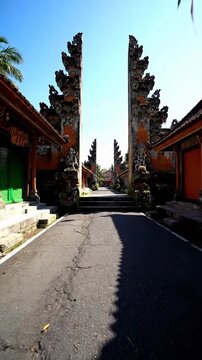 Ancient Balinese split gate path with palm tree shadows