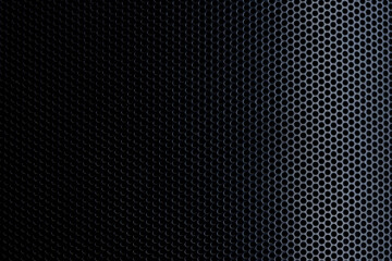 Obraz premium Black Perforated Metal Mesh Texture Background,Close-up of a black metallic speaker grille or perforated steel sheet featuring a repetitive circular hole pattern with dramatic side lighting and dark 