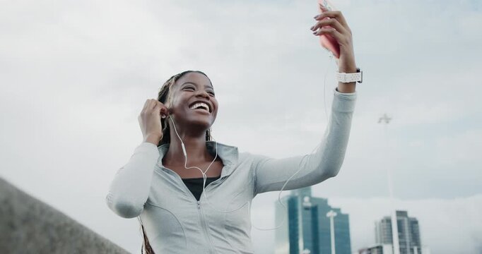Earphones, fitness or happy woman with selfie in city, post workout picture or social media update. Photography, tech or African runner with smile for complete training, low angle or sport influencer