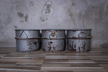 Naklejka premium Three rusty vintage metal drums lined up in a row against a weathered concrete wall background.