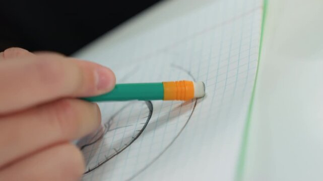 architecture student erasing curved line on grid paper in closeup, hand uses erasertipped pencil to remove graphite and refine contour, subtle blur background and studio lighting emphasize precise