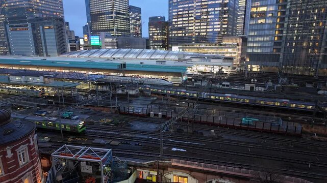 Tokyo, Japan: Tilt up footage of commuter trains rushing in the Tokyo station in the Marunouchi business district in the heart of Tokyo business and financial district at twilight in Japan capital cit