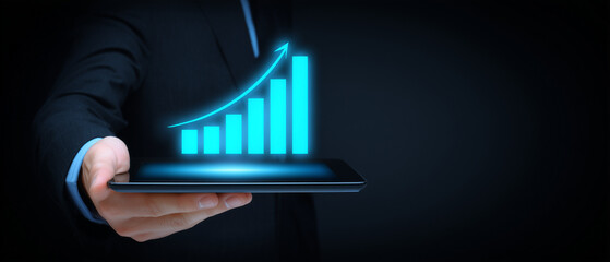businessman holding a tablet with a glowing blue graph and an upward-pointing arrow, representing the concept of business growth