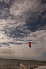 에메랄드빛 바다 위에서 시원하게 바람을 가르며 카이트 서핑을 즐기는 역동적인 해양 스포츠 풍경
