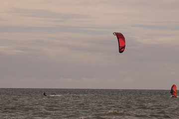 에메랄드빛 바다 위에서 시원하게 바람을 가르며 카이트 서핑을 즐기는 역동적인 해양 스포츠 풍경
