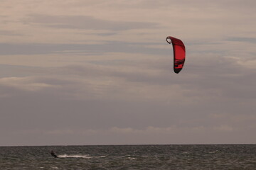 에메랄드빛 바다 위에서 시원하게 바람을 가르며 카이트 서핑을 즐기는 역동적인 해양 스포츠 풍경
