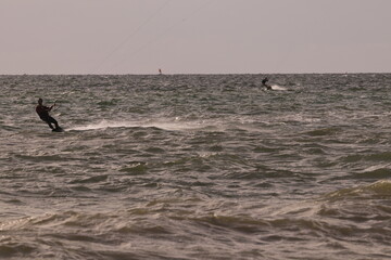 에메랄드빛 바다 위에서 시원하게 바람을 가르며 카이트 서핑을 즐기는 역동적인 해양 스포츠 풍경
