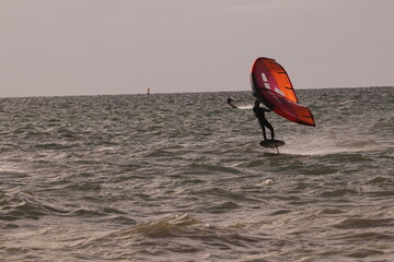 에메랄드빛 바다 위에서 시원하게 바람을 가르며 카이트 서핑을 즐기는 역동적인 해양 스포츠 풍경
