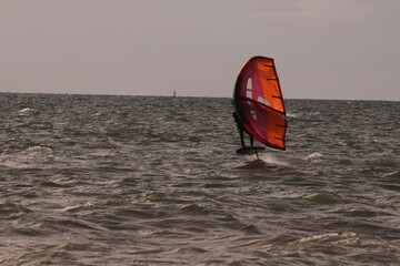 에메랄드빛 바다 위에서 시원하게 바람을 가르며 카이트 서핑을 즐기는 역동적인 해양 스포츠 풍경

