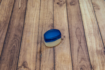 Fototapeta premium A plastic jar full of moisturizing cream on a wooden table