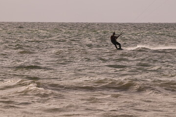 에메랄드빛 바다 위에서 시원하게 바람을 가르며 카이트 서핑을 즐기는 역동적인 해양 스포츠 풍경
