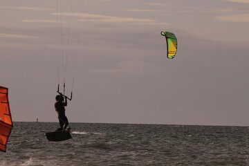 에메랄드빛 바다 위에서 시원하게 바람을 가르며 카이트 서핑을 즐기는 역동적인 해양 스포츠 풍경

