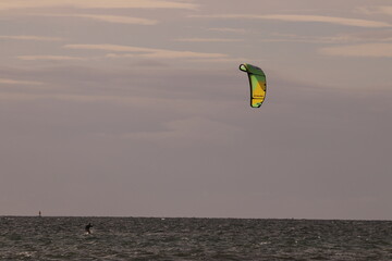 에메랄드빛 바다 위에서 시원하게 바람을 가르며 카이트 서핑을 즐기는 역동적인 해양 스포츠 풍경
