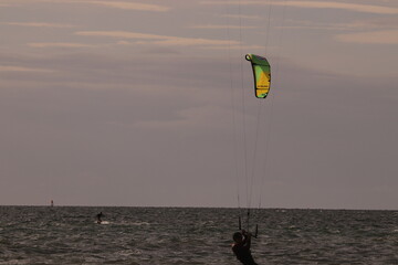 에메랄드빛 바다 위에서 시원하게 바람을 가르며 카이트 서핑을 즐기는 역동적인 해양 스포츠 풍경
