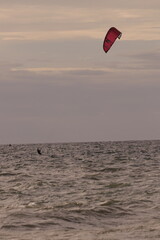 에메랄드빛 바다 위에서 시원하게 바람을 가르며 카이트 서핑을 즐기는 역동적인 해양 스포츠 풍경
