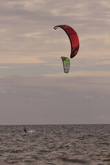 에메랄드빛 바다 위에서 시원하게 바람을 가르며 카이트 서핑을 즐기는 역동적인 해양 스포츠 풍경
