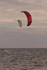 에메랄드빛 바다 위에서 시원하게 바람을 가르며 카이트 서핑을 즐기는 역동적인 해양 스포츠 풍경
