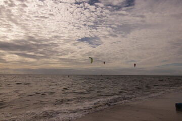 에메랄드빛 바다 위에서 시원하게 바람을 가르며 카이트 서핑을 즐기는 역동적인 해양 스포츠 풍경
