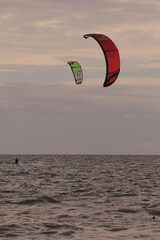 에메랄드빛 바다 위에서 시원하게 바람을 가르며 카이트 서핑을 즐기는 역동적인 해양 스포츠 풍경
