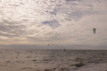 에메랄드빛 바다 위에서 시원하게 바람을 가르며 카이트 서핑을 즐기는 역동적인 해양 스포츠 풍경
