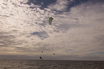 에메랄드빛 바다 위에서 시원하게 바람을 가르며 카이트 서핑을 즐기는 역동적인 해양 스포츠 풍경
