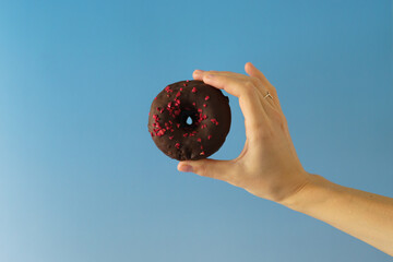 hand holding a chocolate donut