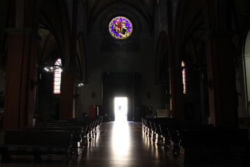 Obraz premium Stained glass window wooden pew entrance silhouette Basilica di San Martino Bologna August 2024