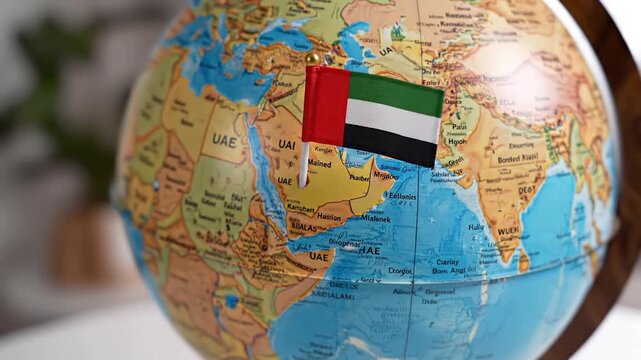 Closeup of a globe with the flag of the United Arab Emirates prominently placed on the countrys location symbolizing travel and international presence.